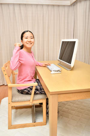 Japanese girl operating personal computer in the living roomの写真素材