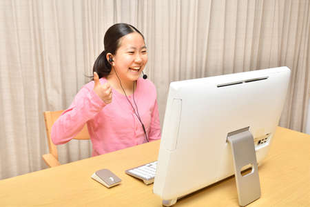 Japanese girl operating personal computer in the living roomの写真素材