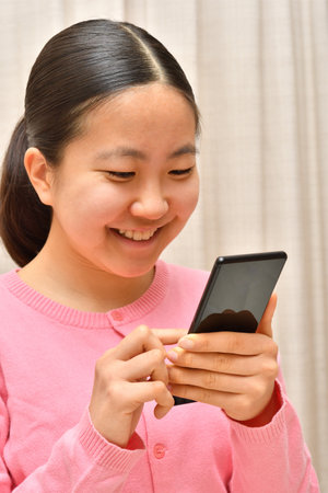 Japanese girl operating her mobile phoneの写真素材