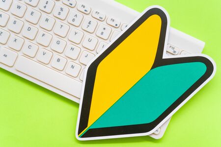 Computer keyboard and beginner mark on green backgroundの写真素材