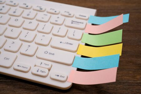 Computer keyboard and lots of  notesの写真素材