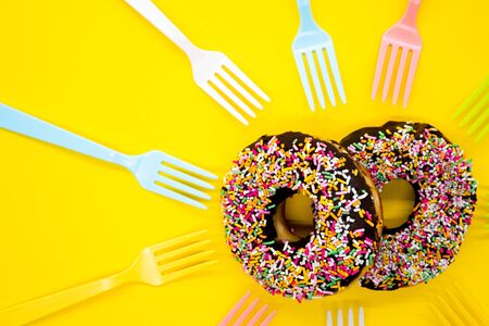 Color spray chocolate donuts on a yellow backgroundの写真素材
