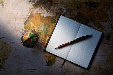 Business notebook with small globe on map backgroundの写真素材