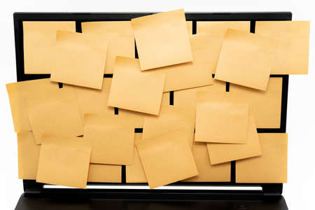 A computer with many sticky notes on it