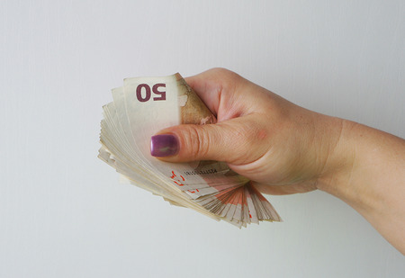 Wad of euro banknotes in the female handの写真素材
