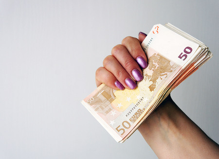 Wad of euro banknotes in the female hand