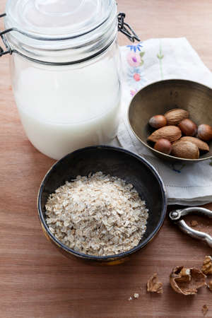 Bowl of raw oats with a jar of homemade oat milkの写真素材