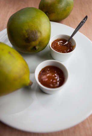 Homemade mango chutney with three ripe mangoesの写真素材