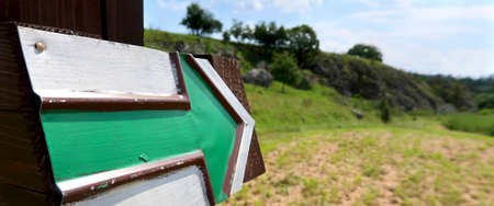 Green arrow sign for hiking tourism in the Czech Republic. Blurred nature path in the background.の写真素材