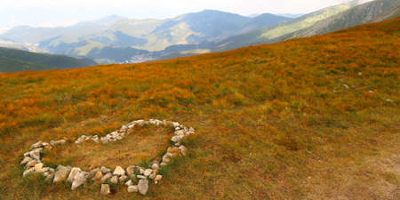 Landscape scenery. Stone heart on the meadow with view of the Low Tatras (Nizke Tatry) on the tourist path to the Chopok mountain peak. Summertime in the Northern Slovakia, Slovak Republic, Europe.の写真素材