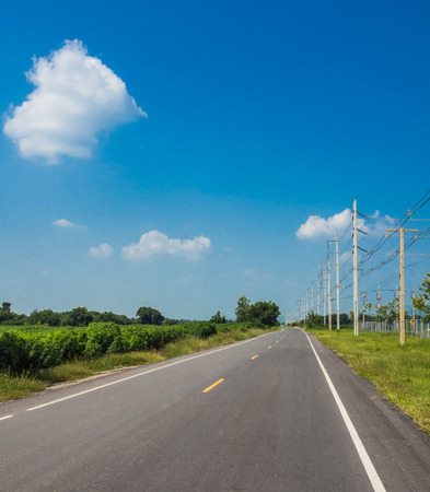 Upcounry paved road  with electricity pole and blue skyの写真素材