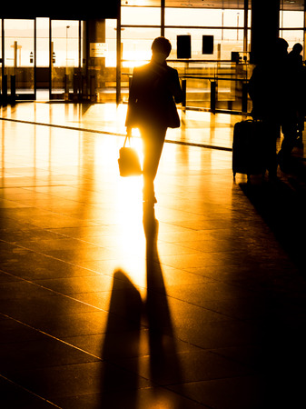 Silhouette traveling businessman in international airport preparing for departureの写真素材