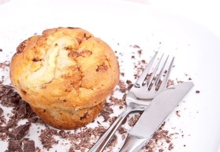 Bright muffins with chocolate pieces and cutlery on a plateの写真素材