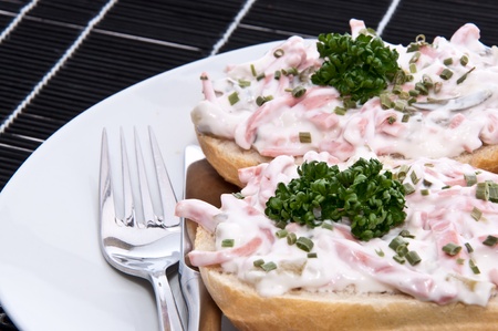Rolls with fresh meat salad decorated with parsley on a plateの写真素材