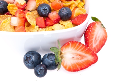 Cornflakes with fresh fruits in a bowl isolated on white background