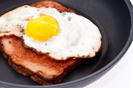 Meat loaf and fried egg in a skillet isolated on white backgroundの写真素材