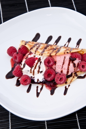Fresh made Raspberry Ice Cream in a Pan Cake decorated with fresh Raspberries and Chocolate Syrupの写真素材