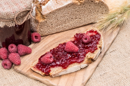 Slice of bread with Raspberry Jam on rustic backgroundの写真素材
