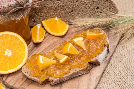 Bread with Orange Jam and fresh fruits on rustic backgroundの写真素材