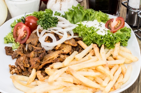 Portion of Kebab meat on a plate on wooden backgroundの写真素材