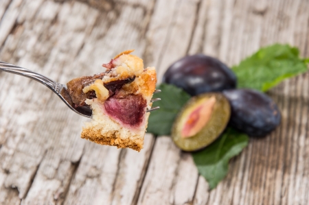 Plum Cake on a fork on wooden backgroundの写真素材