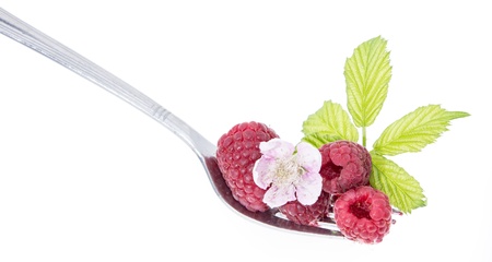 Raspberries on a fork against white backgroundの写真素材