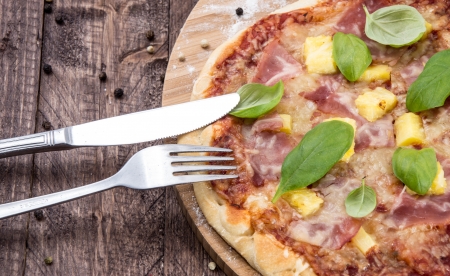Fresh baked Pizza with Ham and Pineapples on wooden backgroundの写真素材