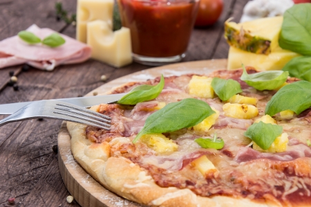 Fresh made Hawaiian Pizza on wooden backgroundの写真素材
