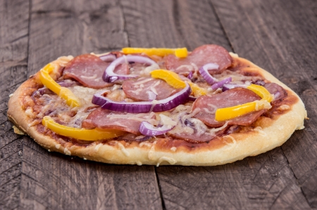 Fresh baked Pizza with Salami on wooden backgroundの写真素材