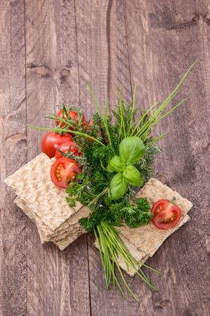 Crispbread with fresh Herbs on wooden backgroundの写真素材