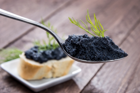 Caviar and Dill on a Spoon against wooden backgroundの写真素材