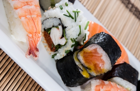 Mixed Sushi rolls with bamboo in the backgroundの写真素材