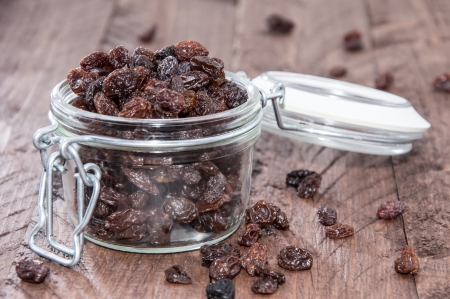 Raisins in a glass on wooden backgroundの写真素材