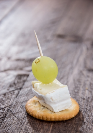 Cracker with Camembert and a Grape on wooden backgroundの写真素材
