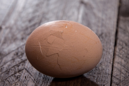 Cracked egg on wooden backgroundの写真素材