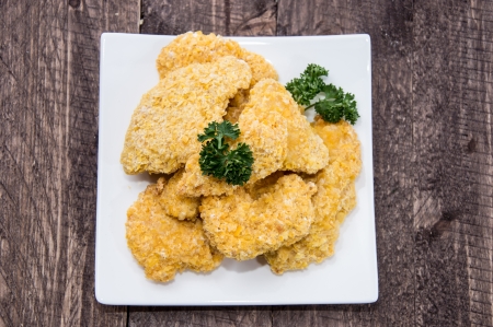 Plate with Chicken Nuggets on wooden background