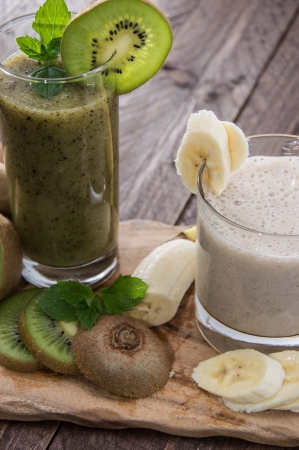 Kiwi- and Banana smoothie on wooden backgroundの写真素材
