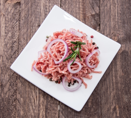 Minced Meat on a plate on wooden backgroundの写真素材