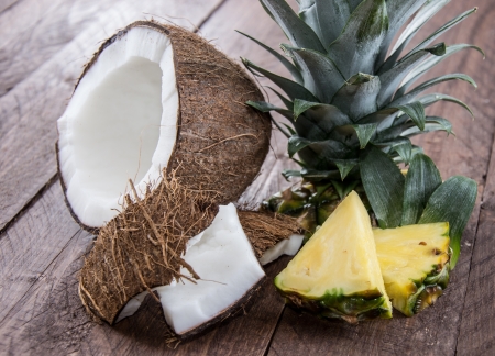Pineapple and Coconut Pieces on wooden backgroundの写真素材