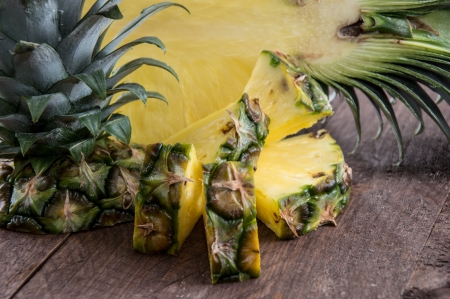 Pineapple pieces on wooden backgroundの写真素材
