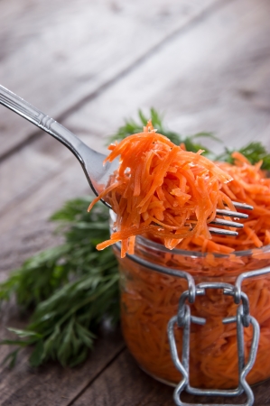 Fork with Carrot Salad in front of a Glassの写真素材