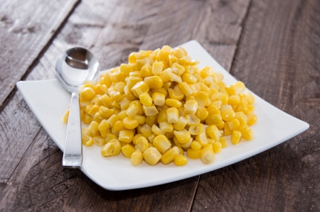 Plate with Corn on wooden backgroundの写真素材