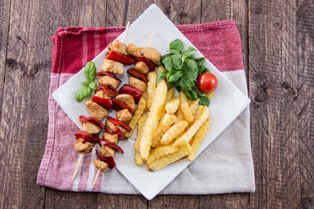 Grilled Skewer with French Fries on wooden backgroundの写真素材