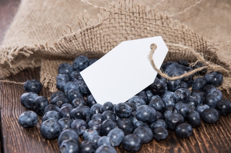Blueberries with empty tag on wooden backgroundの写真素材