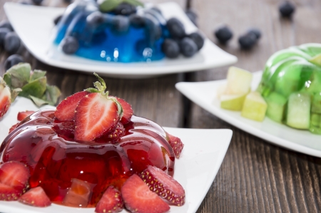 Red, green and blue Jelly with fresh fruits on wooden backgroundの写真素材