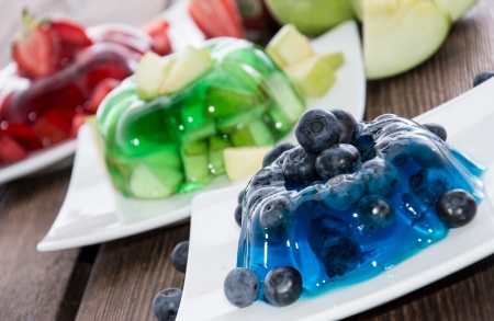 Red, green and blue Jelly with fresh fruits on wooden backgroundの写真素材