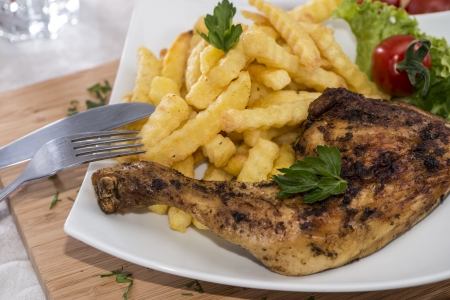 Grilled Chicken with french fries on a plateの写真素材