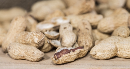 Heap of Peanuts on rustic wooden background (macro shot)