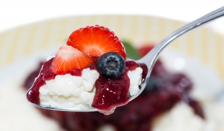 Rice Pudding with fruits on a spoon isolated on whiteの写真素材