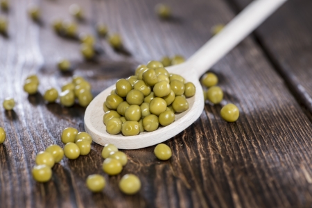 Peas on a wooden spoon (macro shot)の写真素材